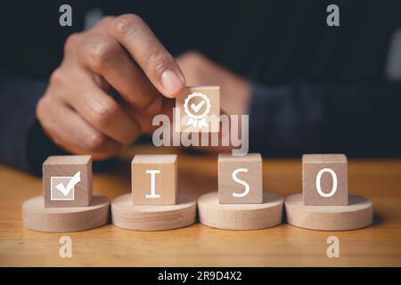 Der Finger eines Geschäftsmannes, der ISO-Holzwürfel drückt Stockfoto