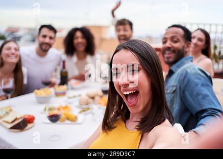 Eine Gruppe multiethnischer Freunde, die ein Selfie bei einem gesellschaftlichen Treffen auf einem Dach machen. Stockfoto
