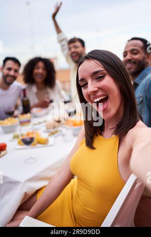 Eine Gruppe multiethnischer Freunde, die ein Selfie bei einem gesellschaftlichen Treffen auf einem Dach machen. Stockfoto