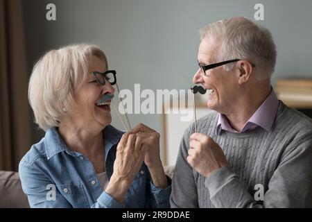 Reife Ehepaare mit lustigen Partyzubehör Stockfoto