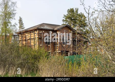 Unvollendetes Ziegelhaus mit präsentiertem Holzgerüst. Bau eines neuen Hauses Stockfoto
