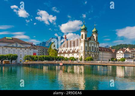 Malerischer Blick auf die Jesuitenkirche Luzern Francis Xavier am Fluss Reuss mit der Brücke Rathaussteg vorne und den Bergen hinten... Stockfoto