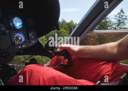 Pilot Helicopter Emergency Medical Service während des Fluges über dem Wald. Nahaufnahme der Flugkontrolle im Cockpit. Stockfoto