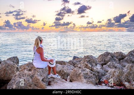 Eine Frau, die den Sonnenuntergang am Fort Zachary Beach Key West, Florida, USA, beobachtet Stockfoto