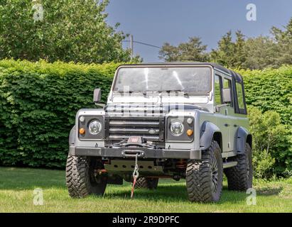 Der vordere Teil eines Land Rover Defenders, der im Gras geparkt ist Stockfoto