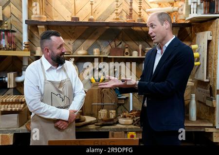 Der Prinz von Wales (rechts) mit Trainer Rob Cox während eines Besuchs im Faithworks Carpentry Workshop in Bournemouth, Dorset, als Teil seiner Reise durch Großbritannien, um ein Projekt zur Beendigung der Obdachlosigkeit zu starten. Foto: Montag, 26. Juni 2023. Stockfoto