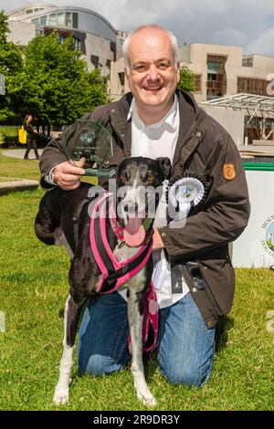 EDITORIAL USE ONLY Joy, der Greyhound, mit Mark Ruskell MSP, wird als Gewinner des diesjährigen Wettbewerbs Holyrood Dog of the Year bekannt gegeben, der gemeinsam von Dogs Trust und dem Kennel Club, Edinburgh, organisiert wird. Foto: Montag, 26. Juni 2023. Die Nächstplatzierten sind als Kura und Tess White bekannt gegeben worden, und auf dem dritten Platz Oakley mit Alison Johnson. Die „pawbischen“ Wahlsieger waren Freude mit Mark Ruskell. Der jährliche Wettbewerb steht allen Eckzähnen von Mitgliedern des schottischen Parlaments oder Hunden des Dogs Trust in Verbindung mit MSPs offen und feiert die besondere Beziehung zwischen Mensch und Handwerk Stockfoto