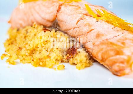 Ein Teller mit goldbraunem Risotto garniert mit einem frisch zubereiteten Fischgericht, das das perfekte Frühstück bietet. Stockfoto