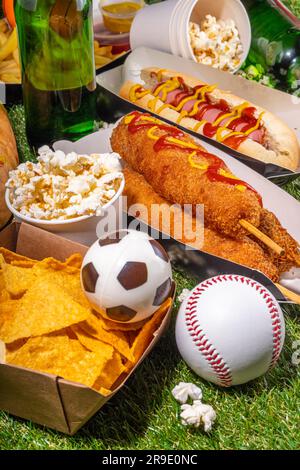 Traditionelles Sportstadionessen und Bierhintergrund, verschiedene Baseball-, Basketball-, Fußball-Fans und Stadion-Snacks, Chips, Saucen, Hot Dogs wi Stockfoto