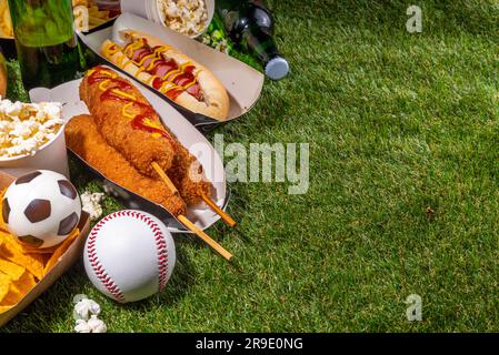 Traditionelles Sportstadionessen und Bierhintergrund, verschiedene Baseball-, Basketball-, Fußball-Fans und Stadion-Snacks, Chips, Saucen, Hot Dogs wi Stockfoto