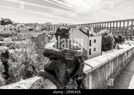 Segovia, Spanien - 18. FEBRUAR 2022: Lustige Skulptur eines Teufels, die ein Selfie gegen das antike römische Aquädukt von Segovia macht, dem wichtigsten Symbol von Segovi Stockfoto