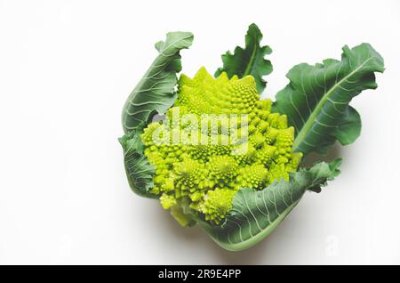 Romanesco Brokkoli mit Blättern auf weißem Hintergrund mit Kopierraum. Stockfoto