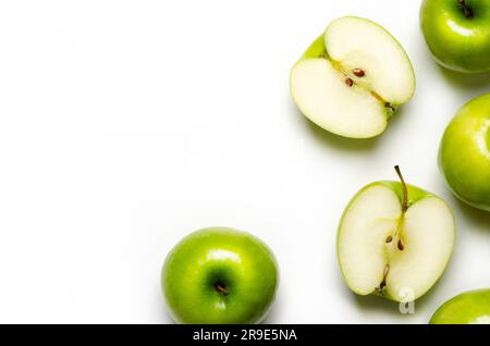 Grüne ganze und geschnittene Äpfel auf weißem Hintergrund mit Kopierraum. Stockfoto