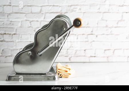 Butternusskürbis-Teig in einer Nudelmaschine auf Marmorhintergrund. Stockfoto