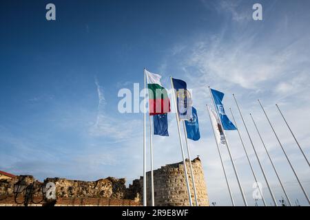 Nessebar, Bulgarien - Juni 2023: Flagge, die Bulgarien und die UNESCO im Wind gegen den blauen Himmel winkt Stockfoto