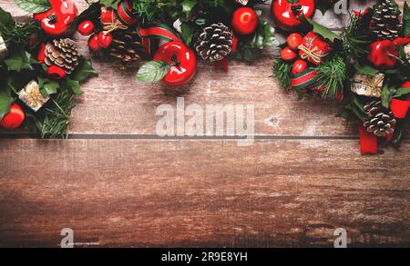 Weihnachtsdekoration in Rot, Grün und Braun auf hölzernem Hintergrund mit Kopierraum. Stockfoto
