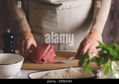 Nahaufnahme der Hände einer Frau, die bereit ist, argentinische Milanesas vorzubereiten. Stockfoto