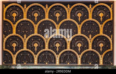 Europäische Tür im Art déco-Stil mit goldenen Dekorelementen in Fischschuppen, architektonische Details aus Madrid, Spanien Stockfoto