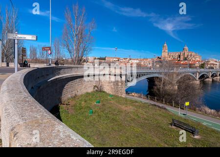 Salamanca, Spanien - 20. Februar 2022: Blick auf die Skyline von Salamanca mit Kathedrale und Enrique-Estevan-Brücke am Tormes River bei herrlichem Sonnenuntergang. Stockfoto