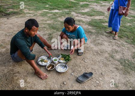 Churachandpur, Indien. 21. Juni 2023. Die Leute nehmen Essen vor einem provisorischen Hilfslager im Dorf Saikot mit. Am 3. Mai 2023 brach im nordöstlichen indischen Bundesstaat Manipur ein ethnischer Konflikt zwischen dem Volk der Meitei, das mehrheitlich im Imphal-Tal lebt, und den Stammesgemeinschaften in den umliegenden Bergen, einschließlich Kuki und Zo, aus. Mindestens 109 Menschen sind bei ethnisch motivierter Gewalt zwischen der Meitei und den Kuki im indischen Bundesstaat Manipur ums Leben gekommen und über 300 wurden verletzt. Kredit: SOPA Images Limited/Alamy Live News Stockfoto