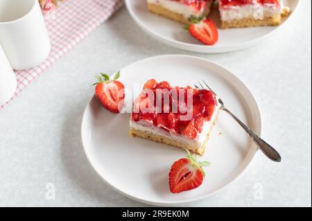 Kuchen mit Erdbeeren, Schlagsahne und Mascarpone-Käse auf dem Teller Stockfoto