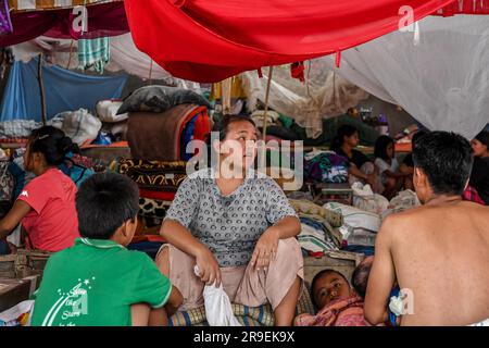 Churachandpur, Indien. 21. Juni 2023. Eine Frau sitzt mit ihrer Familie in einem provisorischen Hilfslager im Dorf Saidan. Am 3. Mai 2023 brach im nordöstlichen indischen Bundesstaat Manipur ein ethnischer Konflikt zwischen dem Volk der Meitei, das mehrheitlich im Imphal-Tal lebt, und den Stammesgemeinschaften in den umliegenden Bergen, einschließlich Kuki und Zo, aus. Mindestens 109 Menschen sind bei ethnisch motivierter Gewalt zwischen der Meitei und den Kuki im indischen Bundesstaat Manipur ums Leben gekommen und über 300 wurden verletzt. (Foto: Biplov Bhuyan/SOPA Images/Sipa USA) Guthaben: SIPA USA/Alamy Live News Stockfoto