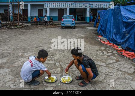 Churachandpur, Indien. 21. Juni 2023. Kinder essen in einem Hilfslager im Dorf Rengkia. Am 3. Mai 2023 brach im nordöstlichen indischen Bundesstaat Manipur ein ethnischer Konflikt zwischen dem Volk der Meitei, das mehrheitlich im Imphal-Tal lebt, und den Stammesgemeinschaften in den umliegenden Bergen, einschließlich Kuki und Zo, aus. Mindestens 109 Menschen sind bei ethnisch motivierter Gewalt zwischen der Meitei und den Kuki im indischen Bundesstaat Manipur ums Leben gekommen und über 300 wurden verletzt. (Foto: Biplov Bhuyan/SOPA Images/Sipa USA) Guthaben: SIPA USA/Alamy Live News Stockfoto