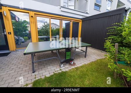 Wunderschöne Aussicht auf Tischtennistennis im Garten vor dem modernen Stadthaus mit Spiegelfenstern. Schweden. Stockfoto