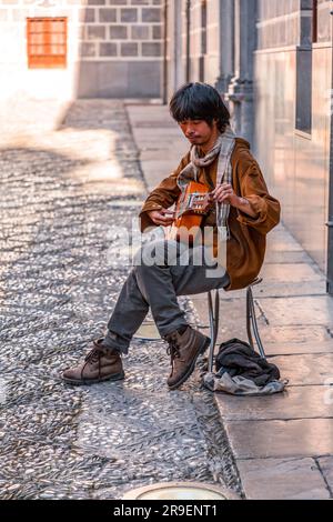 Granada, Spanien - 22. Februar 2022: Junger Gitarrenspieler tritt in den Straßen von Granada, Spanien auf. Stockfoto