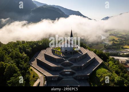 Drohnenblick auf die St.-Anton-Kirche und das Kobarid-Ossarium in Slowenien. Caporetto Memorial aus dem Ersten Weltkrieg. Stockfoto