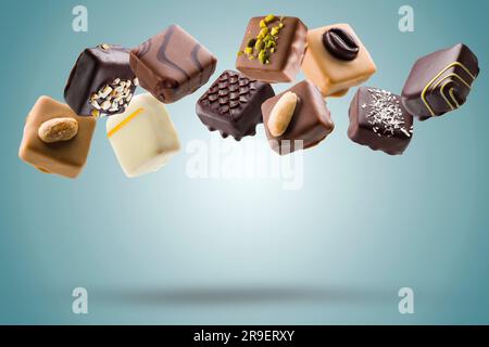 Verschiedene Pralinen aus Schokolade auf blauem Hintergrund Stockfoto