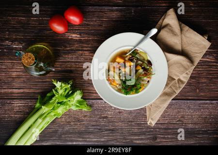 Top-down-Shot von gesundem veganem Minestrone mit Süßkartoffeln, Sellerie, Tomaten und Bohnen. Gesunde Ernährung. Veganes Diätkonzept. Stockfoto