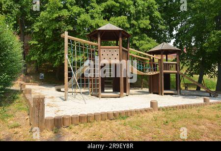 Kinderspielplatz Bau von Holzhütten, Kletternetzbrücke und Sandboden Stockfoto