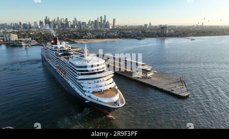 Melbourne, VIC, Australien - 10. Dez. 2022 - Queen Elizabeth Kreuzfahrtschiff, das bei Sonnenaufgang in Melbourne ankommt, mit Stadtbild im Hintergrund und Ballons Stockfoto