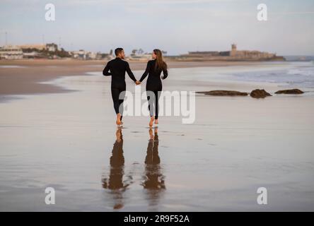 Rückansicht Eines Romantischen Jungen Paares, Das Zusammen Am Strand Läuft Stockfoto