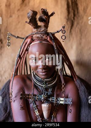 Junge Himba-Frau mit traditionellem Schmuck in ihrem Dorf in Namibia, Afrika. Stockfoto
