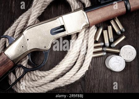 Gewehre des alten Westens. Hebelbetätigte Wiederholgewehre mit Munition auf einem Holztisch Stockfoto