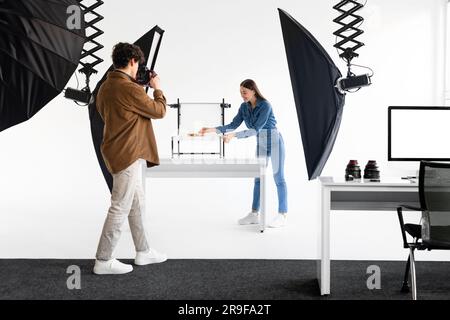 Professionelles Team aus Fotografen und smm-Managern, die Inhalte im Fotostudio aufnehmen und mit modernen Geräten arbeiten Stockfoto