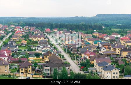 Perm, Russland - 04. Juni 2023: Vorstadtgebiet mit Wohngebäuden in einer bewaldeten Gegend, Draufsicht Stockfoto