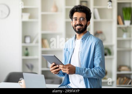 Porträt Eines Gutaussehenden Indischen Freiberuflers Mit Digital Tablet In Den Händen Stockfoto