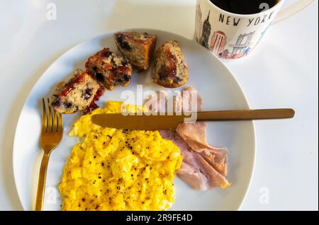 Rührei, Schinken, Muffin und schwarzer Kaffee in einer New Yorker Tasse Stockfoto