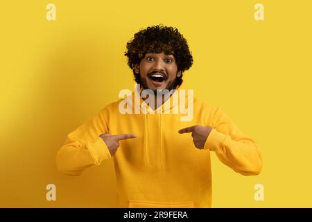Schockierter, glücklicher, junger indianer, der auf sich selbst zeigt Stockfoto