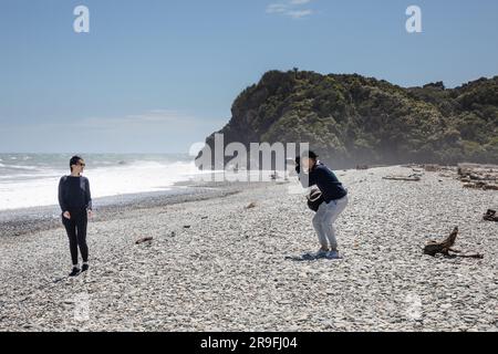 Touristen machen Fotos am WindSwept Ship Creek Beach Westküste Neuseeland South Island Tasman Sea Haast Coast. Foto: Rob Watkins Stockfoto