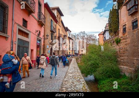 Granada, Spanien – 26. Februar 2022: Steinbrücke und traditionelle maurische spanische Architektur rund um den Fluss Darro, Granada, Spanien. Stockfoto