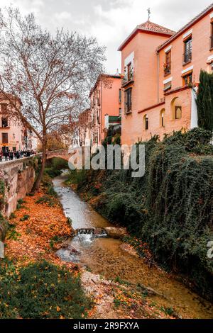 Granada, Spanien – 26. Februar 2022: Steinbrücke und traditionelle maurische spanische Architektur rund um den Fluss Darro, Granada, Spanien. Stockfoto