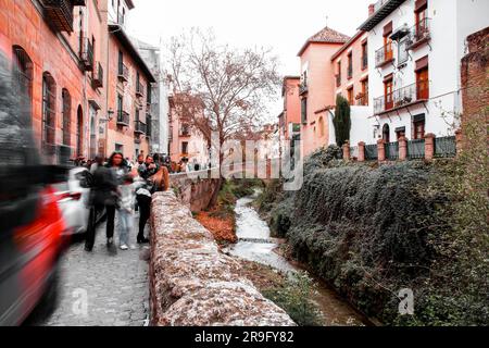 Granada, Spanien – 26. Februar 2022: Steinbrücke und traditionelle maurische spanische Architektur rund um den Fluss Darro, Granada, Spanien. Stockfoto