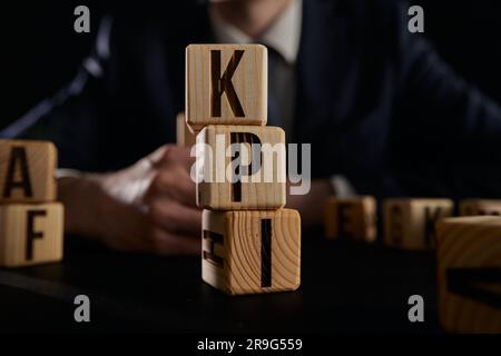 Geschäftsmann hat Wort-kpi mit Holzbausteinen erstellt. Stockfoto