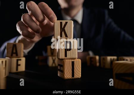 Geschäftsmann hat Wort-kpi mit Holzbausteinen erstellt. Stockfoto