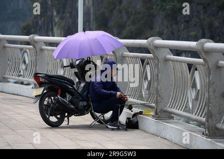 Ha Long, Vietnam - 19. März 2023. Ein Mann angelt von einer Brücke in Ha Long Vietnam. Stockfoto