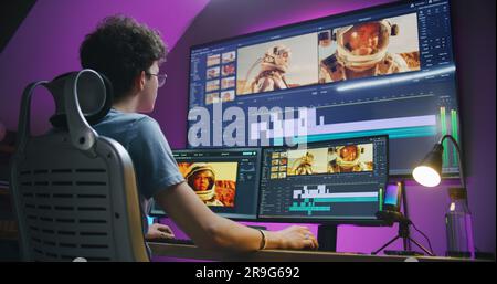 Junger Redakteur, Videofilmer, bearbeitet Tonspuren für Filme mit Astronauten, arbeitet im Home Office. Filmmaterial und Programmoberfläche mit Tools auf Computer und großem digitalen Bildschirm. Postproduction-Konzept. Stockfoto